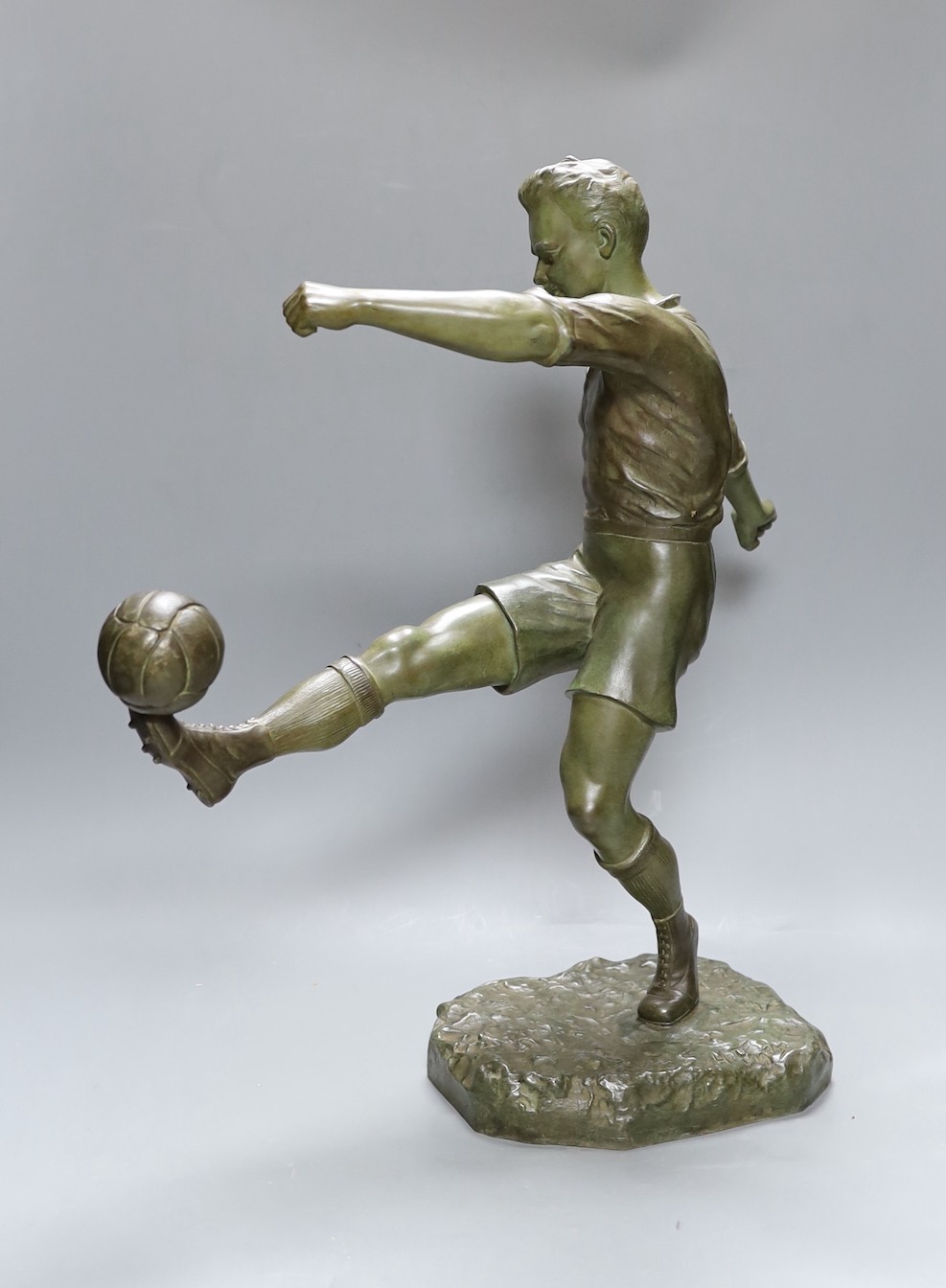 H. Fugere. A large patinated spelter figure of a football player, 50cm tall